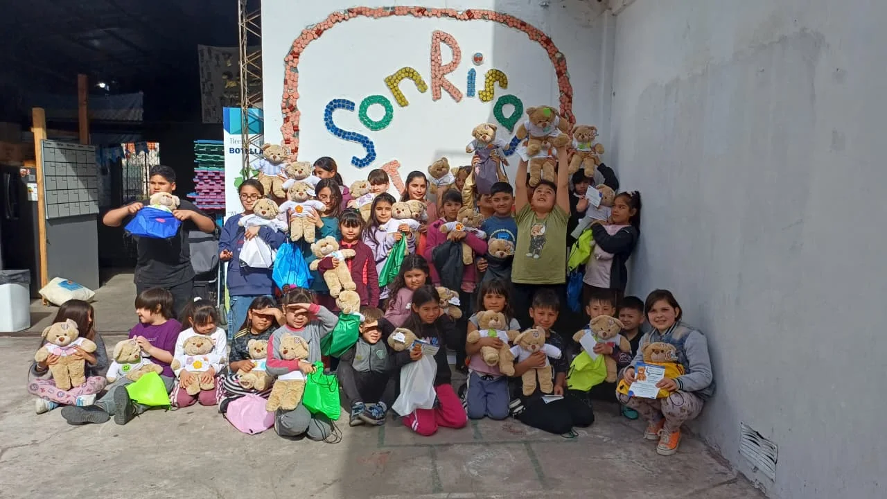 La comunidad reunida frente a un mural de SonRisas