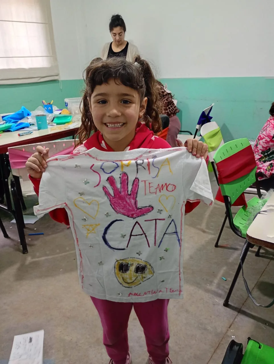 Una chica muestra una remera que intervino en un taller de SonRisas