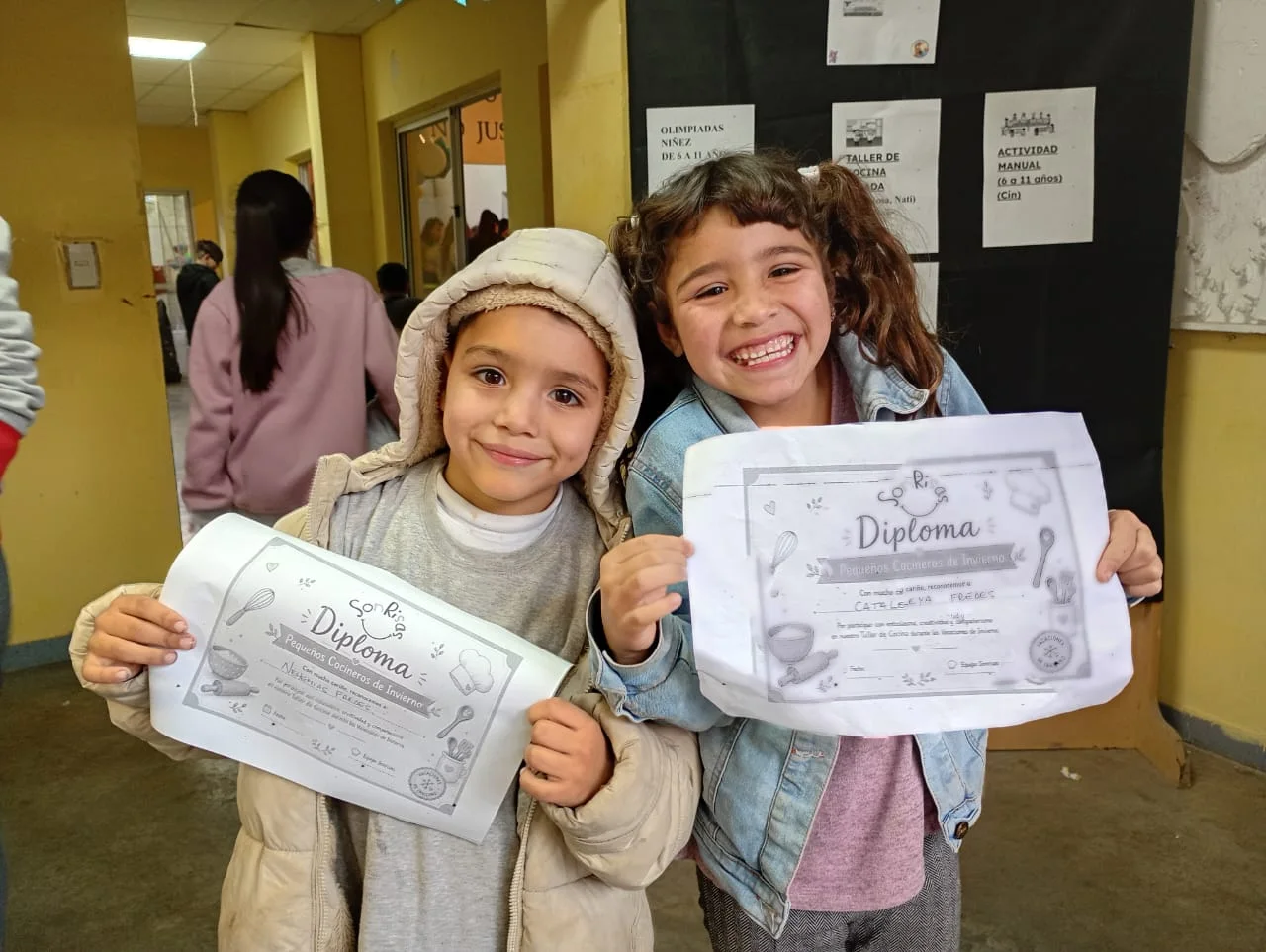 Dos chicas muestran sus diplomas en SonRisas